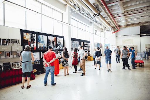 Group of people examining art for sale on a wall