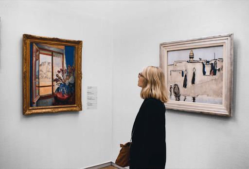 Woman examining a painting in an art gallery